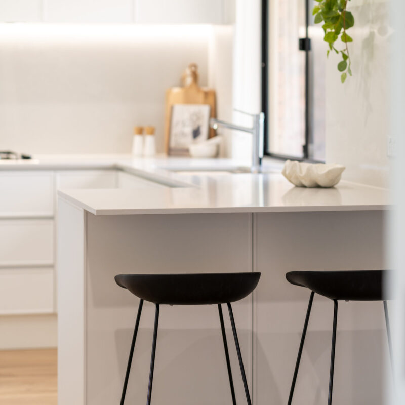 Farquhar Kiev 10 profile in premium white with small island, black stools and black window.