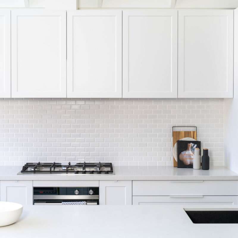 The kitchen is drenched in Farquhar's Premium White cabinetry from top to toe, further illuminating the bright, fresh and open space which has a pitched roof and huge windows allowing an abundance of natural light to flow in.