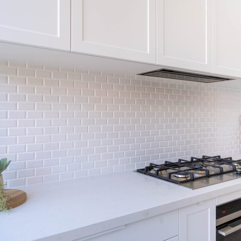 Bright White Cabinetry The kitchen is drenched in Farquhar's Premium White cabinetry from top to toe, further illuminating the bright, fresh and open space which has a pitched roof and huge windows allowing an abundance of natural light to flow in.