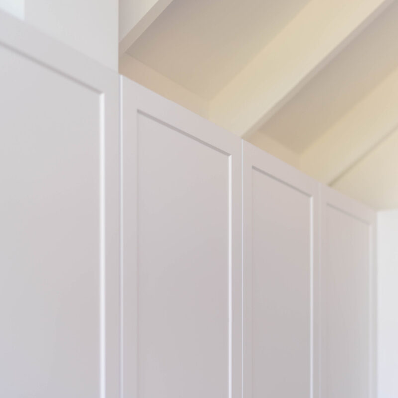 The kitchen is drenched in Farquhar's Premium White cabinetry from top to toe, further illuminating the bright, fresh and open space which has a pitched roof.