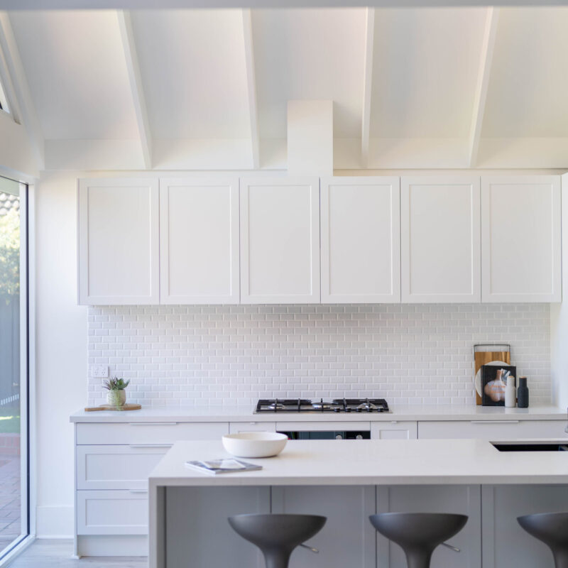 The kitchen is drenched in Farquhar's Premium White cabinetry from top to toe, further illuminating the bright, fresh and open space which has a pitched roof and huge windows allowing an abundance of natural light to flow in.