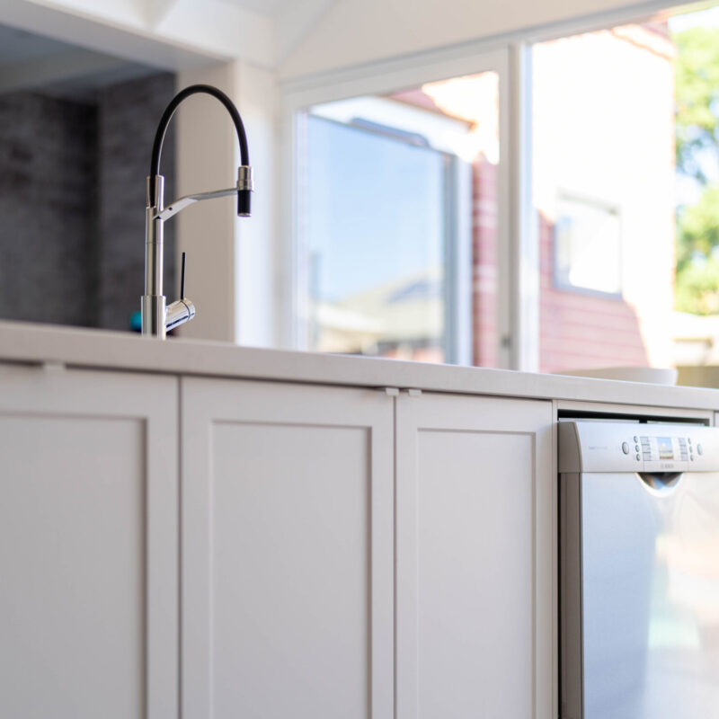 Farquhar Premium White Barossa profile Kitchen island with Oliveri sink and taps and dishwasher.