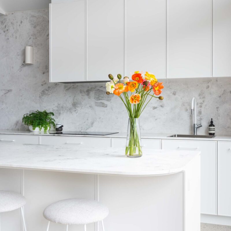 Modern monochrome black and white L shape with Island kitchen. Featuring marble benchtops and splashback.