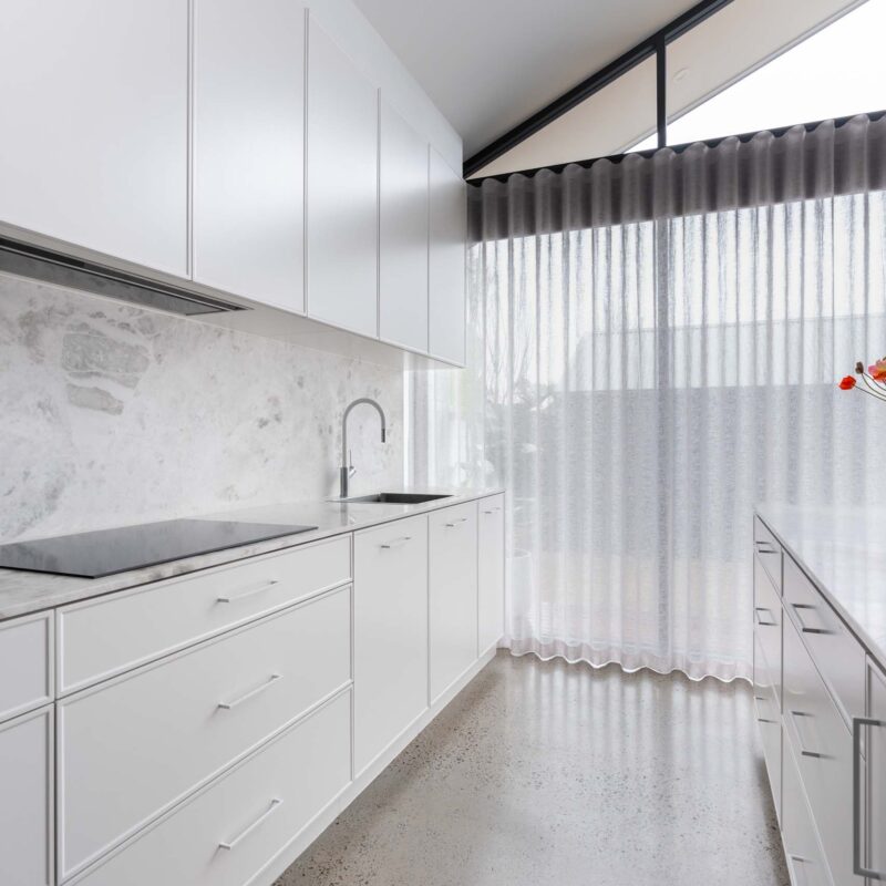 White galley style kitchens. Featuring slim shaker profiled cabinets. Includes a built in inductions cooktop.