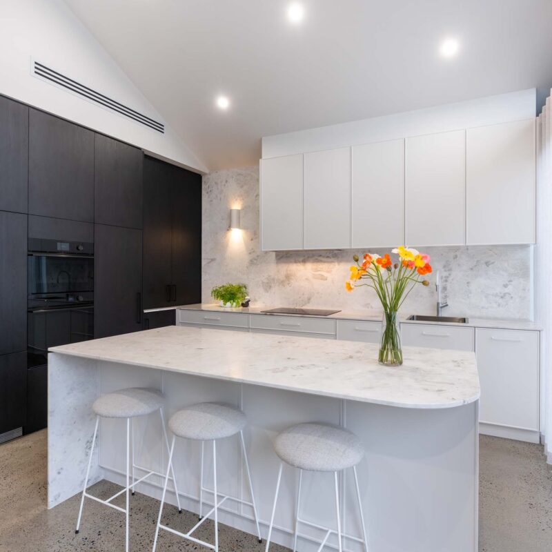 Modern monochrome black and white L shape with Island kitchen. Featuring marble benchtops and splashback.