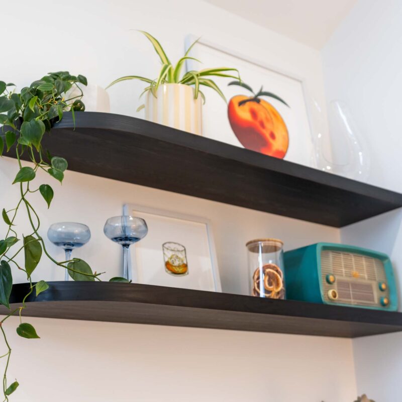 Black timber-grain floating shelves with curved ends