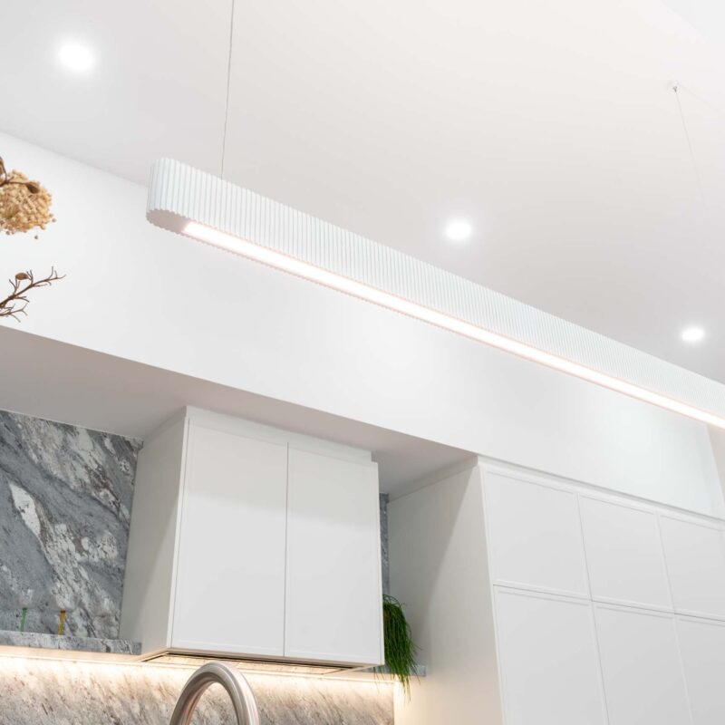 White slim shaker profile cabinets. Long slim pendant feature light.