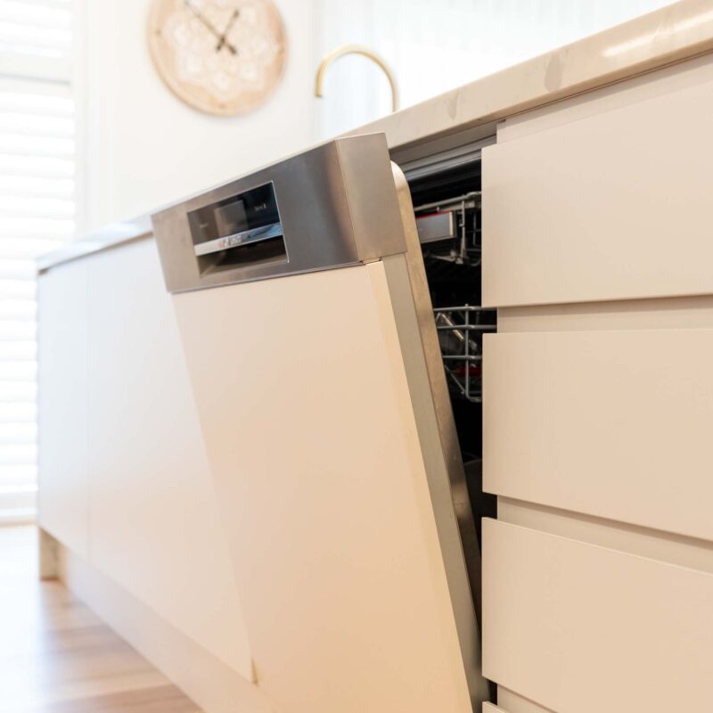 White finger pull cabinets. Semi integrated dishwasher.