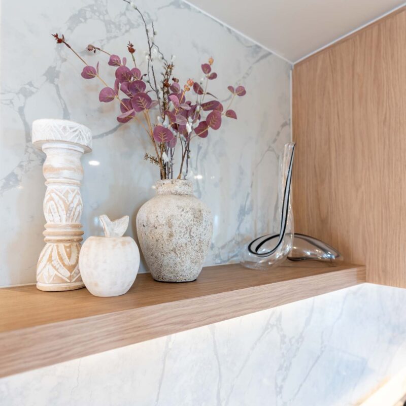 Oak timber-look floating shelf positioned next to a integrated rangehood cabinet.