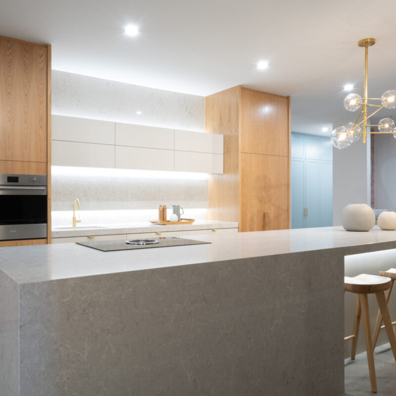 Classic and modern kitchen display at our Marion Road showroom. Featuring a mix of white and timber grain cabinets with an engineered stone benchtop.