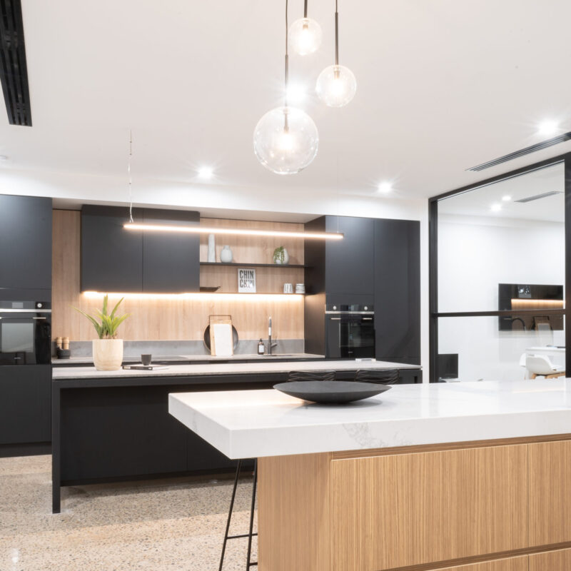 Sleek and industrial kitchen display at the Marion Road Farquhar showroom. Featuring our matte black anti-fingerprint cabinets and 12mm Dekton benchtops in Kovik.