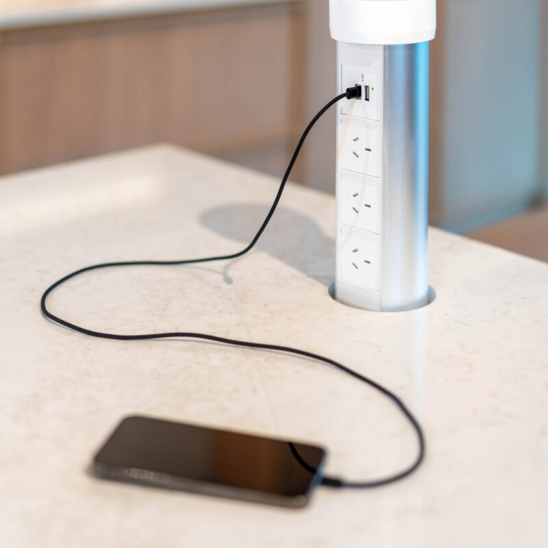 Light solid surface kitchen benchtop featuring a pop-up powerpoint dock.