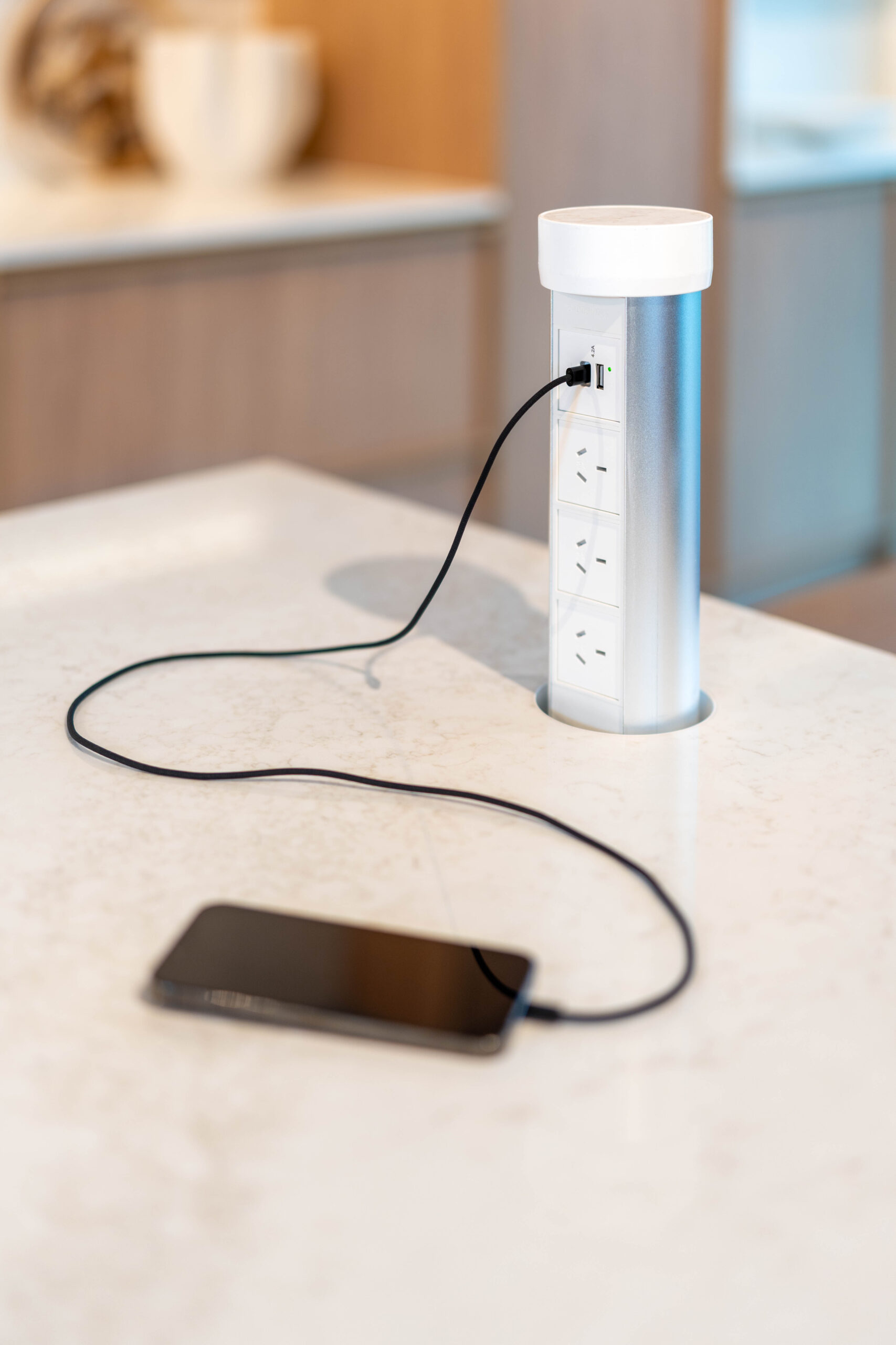 Light solid surface kitchen benchtop featuring a pop-up powerpoint dock.