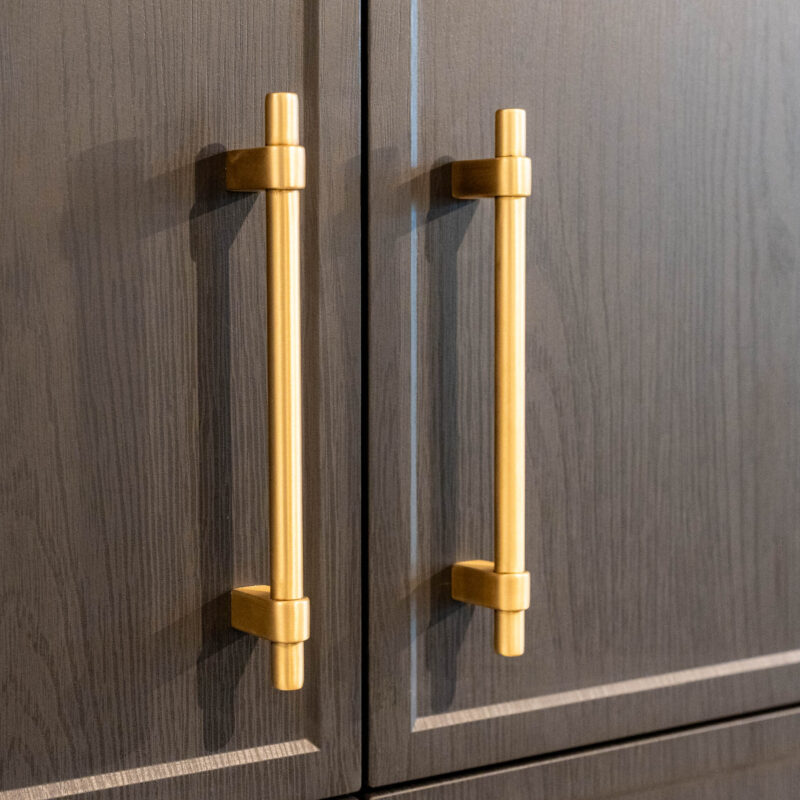 Dark timber grain cabinet doors featuring matte gold handles