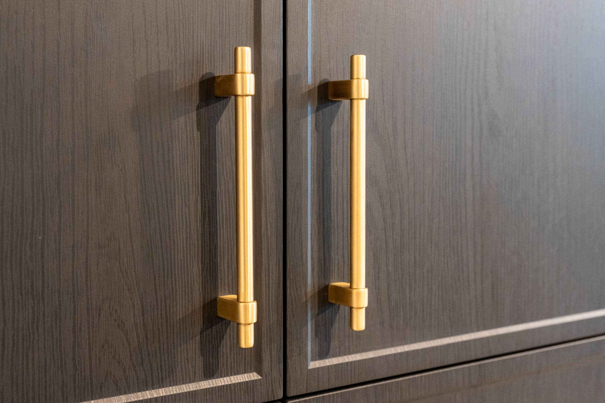 Dark timber grain cabinet doors featuring matte gold handles