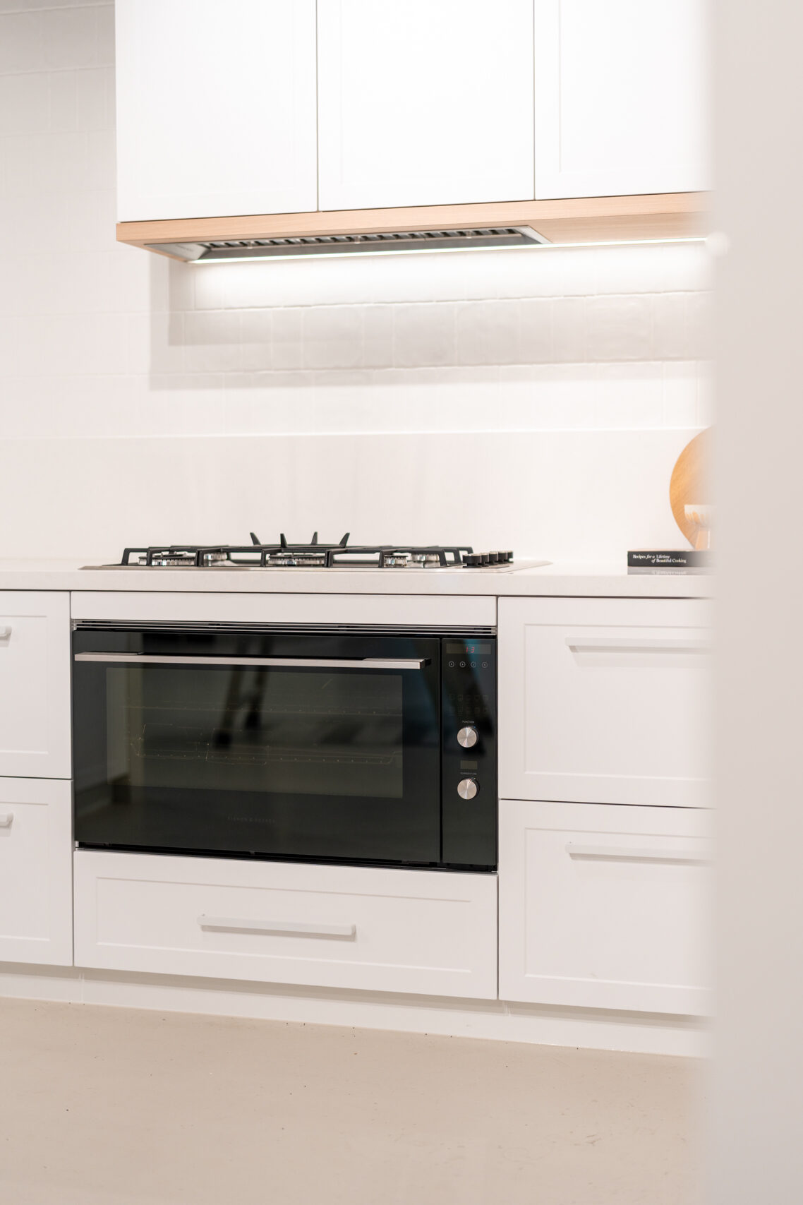 Classic Hampton style kitchen featuring shaker style cabinets, a white engineered stone and timber features.