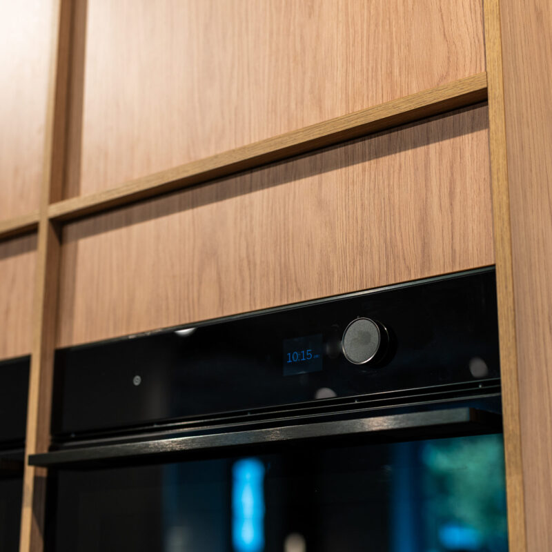 Timber grain cabinetry wall oven tower with 2 x 600 wide ovens side by side.