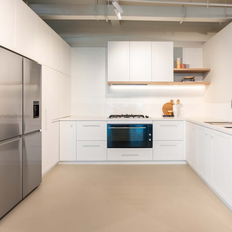 Classic Hampton style kitchen featuring shaker style cabinets, a white engineered stone ad floating timber shelving.