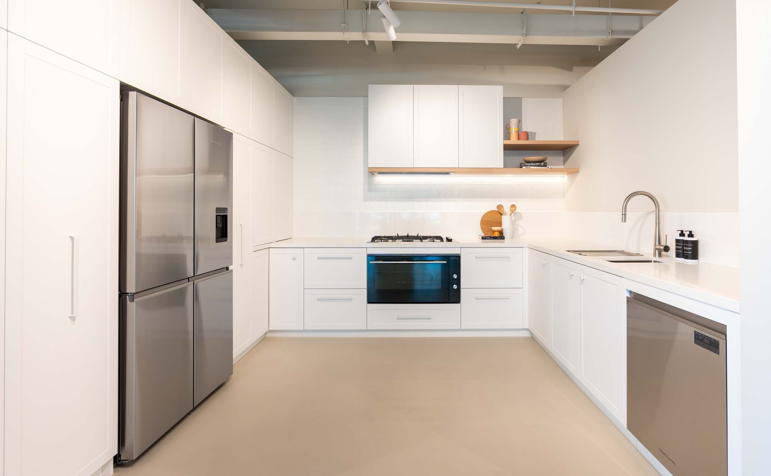 Classic Hampton style kitchen featuring shaker style cabinets, a white engineered stone ad floating timber shelving.