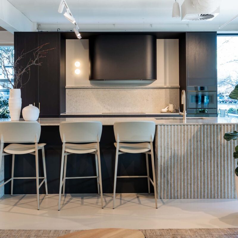 Kitchen display in the Hutt Street Farquhar showroom. Featuring a thin shaker profiled door in timber grain texture graphite colour. Benchtops are Tocco Terranite.