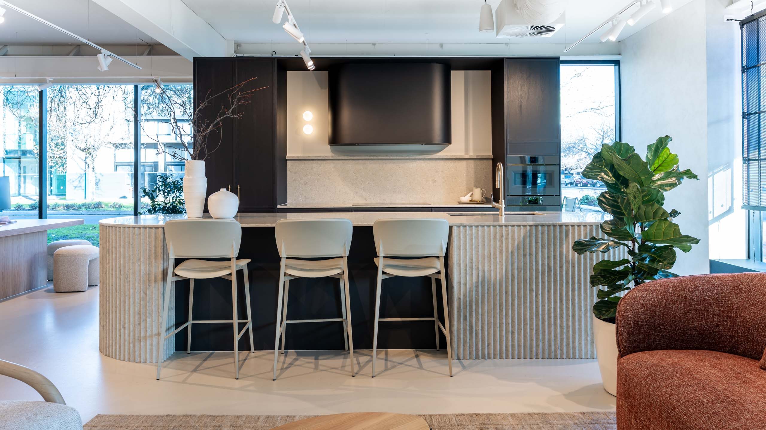 Kitchen display in the Hutt Street Farquhar showroom. Featuring a thin shaker profiled door in timber grain texture graphite colour. Benchtops are Tocco Terranite.