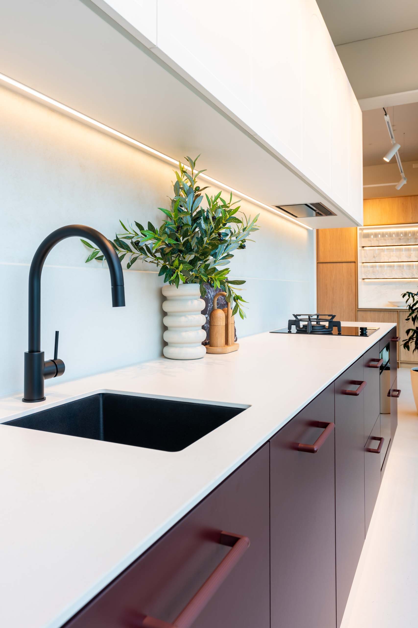Small kitchen with Kalamata laminate cabinets and a light 12mm Dekton Aeris benchtop. Featuring a matt black goose neck mixer tap and under mount sink.
