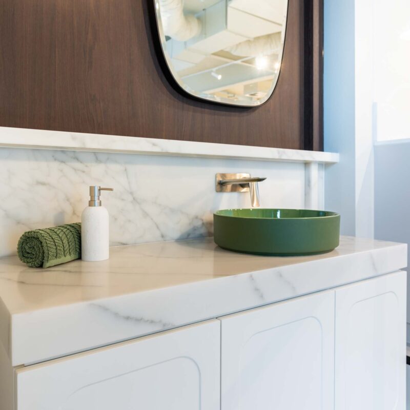 Farquhar Hutt Street showroom vanity display. Featuring white profiles door and a classic thick marble benchtop. Green top mount sink with wall mounted mixer tap.