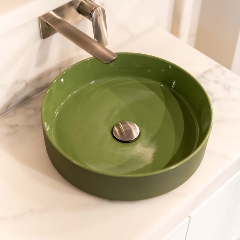 Vanity freaturing a green top mount sink and wall mount stainless steel mixer tap. Installed on a marble benchtop.